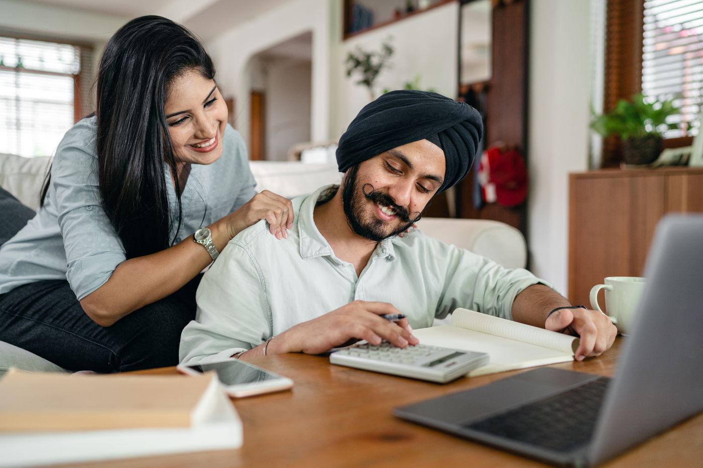 A couple reviewing financial paperwork with a laptop and calculator